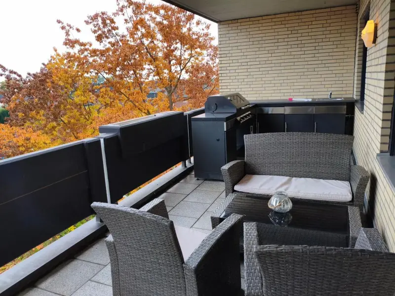 Überdachter Balkon mit Loungeecke und Blick über Warendorf im Herbst