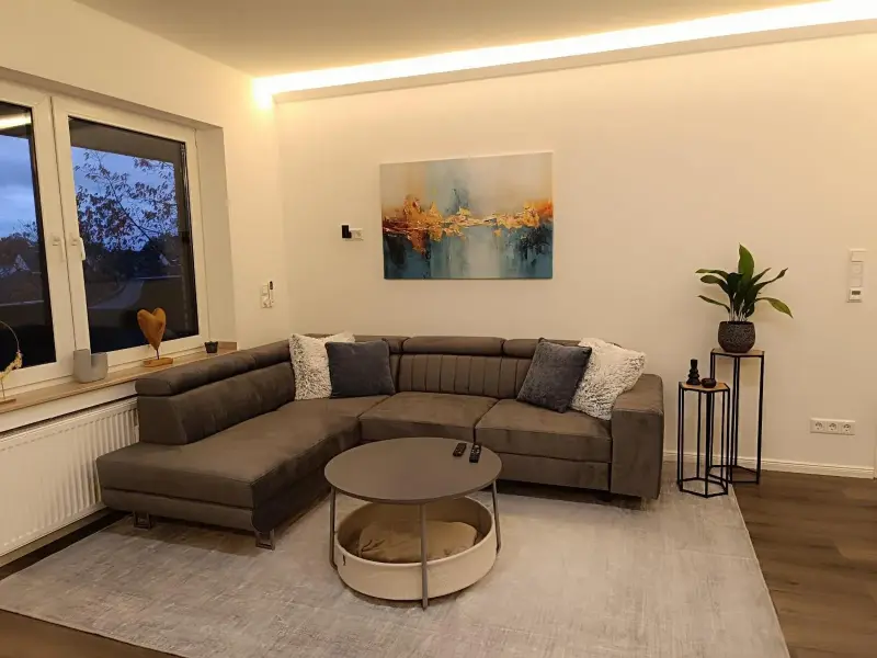 Wohnzimmer mit großem Ecksofa und Fenster
